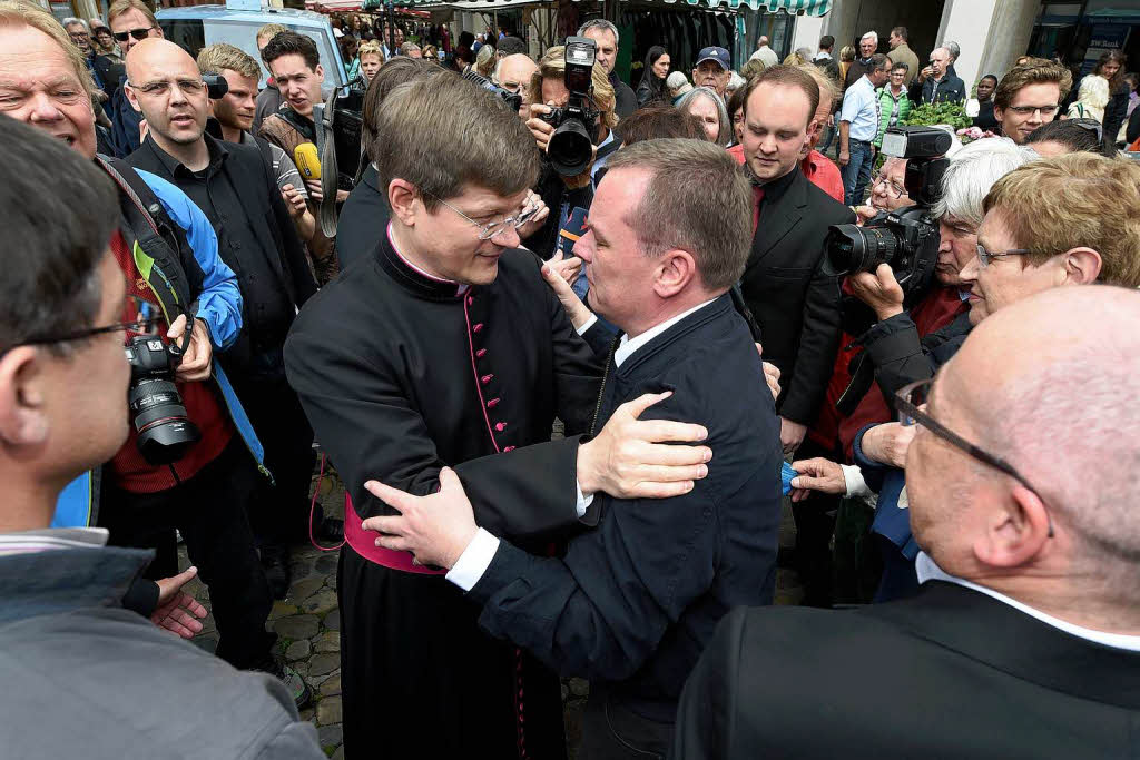 Hier  umarmt Burger einen ehemaligen Mitstudenten, der nun Priester ist.