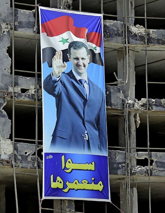 Ein Assad-Plakat hngt im zerstrten Homs.   | Foto: AFP