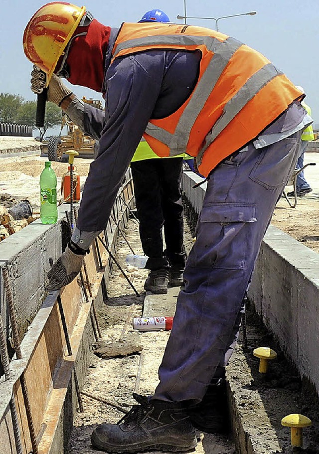 Zwlf Stunden schuften am Tag, sieben ...eiter auf einer WM-Baustelle in Katar   | Foto: dpa