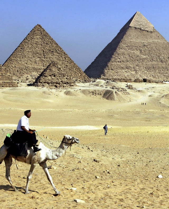 Ein Polizist mit Kamel auf Streife vor der Cheops-Pyramide (rechts)   | Foto: dpa