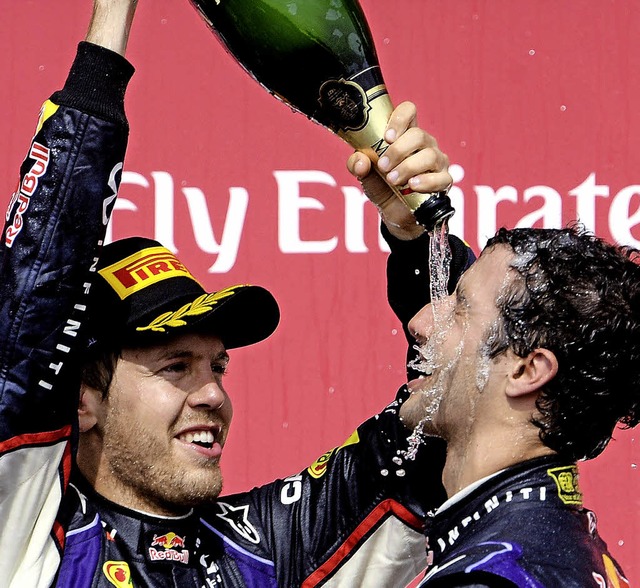 Daniel Ricciardo (rechts) lsst sich vom Dritten Sebastian Vettel begieen.   | Foto: DPA