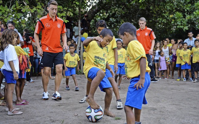 Kicken in der Dorfschule: Mesut zil (...s Ginter messen sich mit Peles Enkeln.  | Foto: dpa