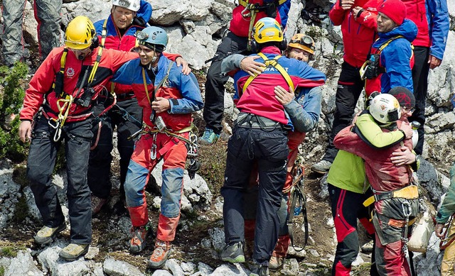 Nach der erfolgreichen Bergungsaktion liegen sich die Retter in den Armen.  | Foto: dpa