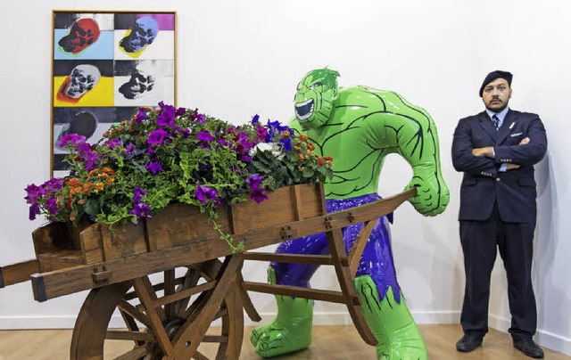 Ein Wachmann bewacht auf der Art Basel eine Hulk-Skulptur von Jeff Koons.   | Foto: dpa