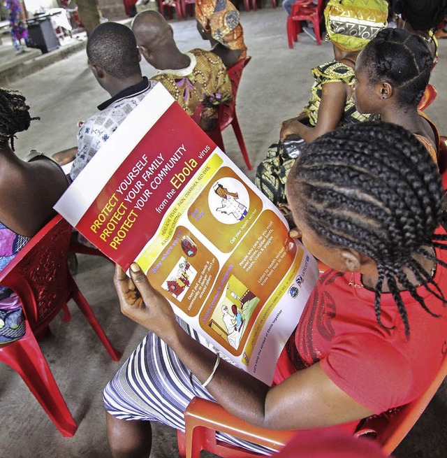 Eine Frau in Liberia liest einen Infozettel der Unicef ber Ebola.   | Foto: dpa