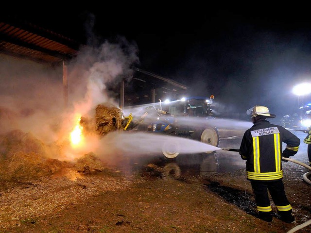 Die Feuerwehr lscht die Strohballen  | Foto: WOLFGANG KUENSTLE               