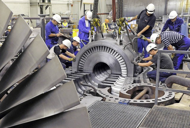 Kraftwerkstechniker montieren eine Turbinenanlage.  | Foto: dpa