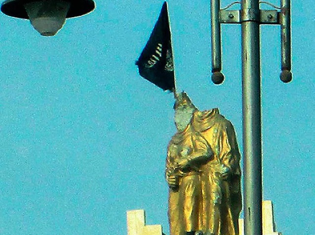 Auf eine  zerstrte Skulpturengruppe  ...Isis-Miliz die eigene Flagge gesetzt.   | Foto: AFP