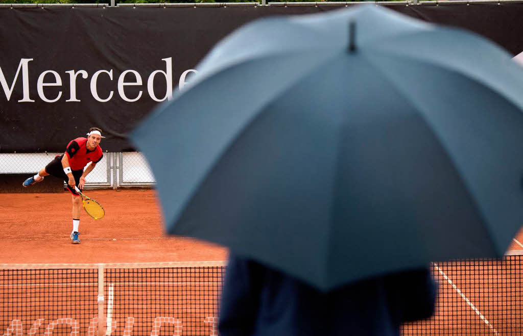 Eine Zuschauer mit Regenschirm betrachtet whrend dem Erstrundenspiel des Mercedes Cup ATP Tennis Turniers in Stuttgart.