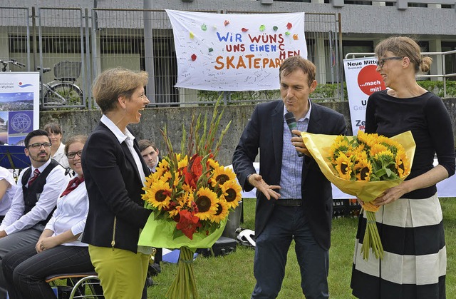 Jrg Lutz bergibt Marion Dammann (lin...ugendliche werben fr einen Skatepark.  | Foto: Martin Eckert