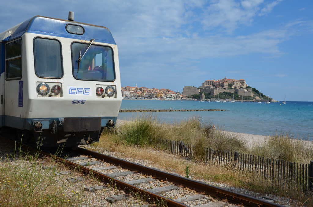 Der Zug, der tglich von Calvi nach L’Ile Rousse fhrt – im Hintergrund die Zitadelle von Calvi