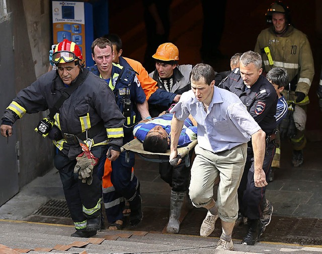 Helfer bergen einen Verletzten aus den Tiefen der Metro.   | Foto: DPA