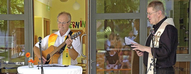 Die Pfarrer Christoph Lauter (links) u...die Weihe der neuen Kinderkrippe vor.   | Foto: J. Schweizer