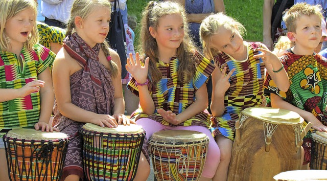 Kinder trommeln in bunten Kleidern.   | Foto: Beatrice Scherer