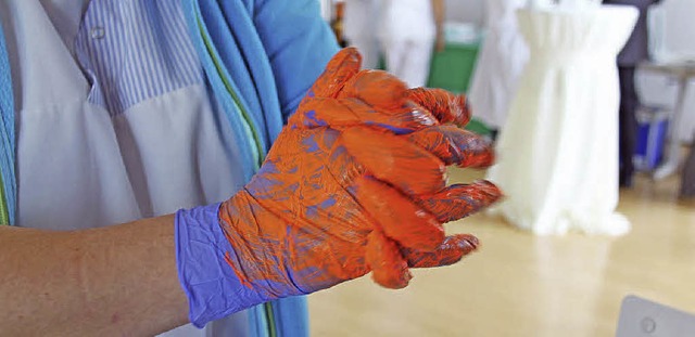 Eine Pflegekraft reibt bei einer Fortb...m Ausziehen der  Handschuhe zu ben.    | Foto: ZVG