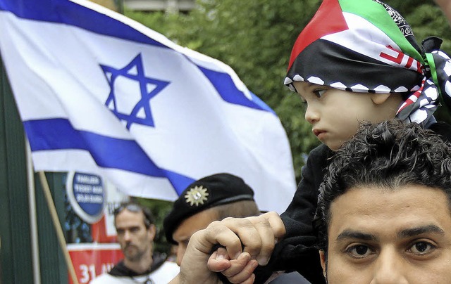 Ein Mann demonstriert in Berlin mit se...ter sind israelische Fahnen zu sehen.   | Foto: DPA