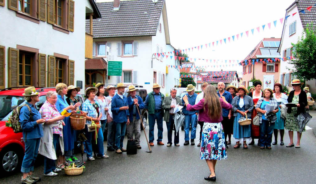 Die Sngerinnen und Snger des Gemischten Chores „Liederkranz“ mit Dirigentin Jeannette Bastian mit ihren Weinliedern beim Winzerumzug