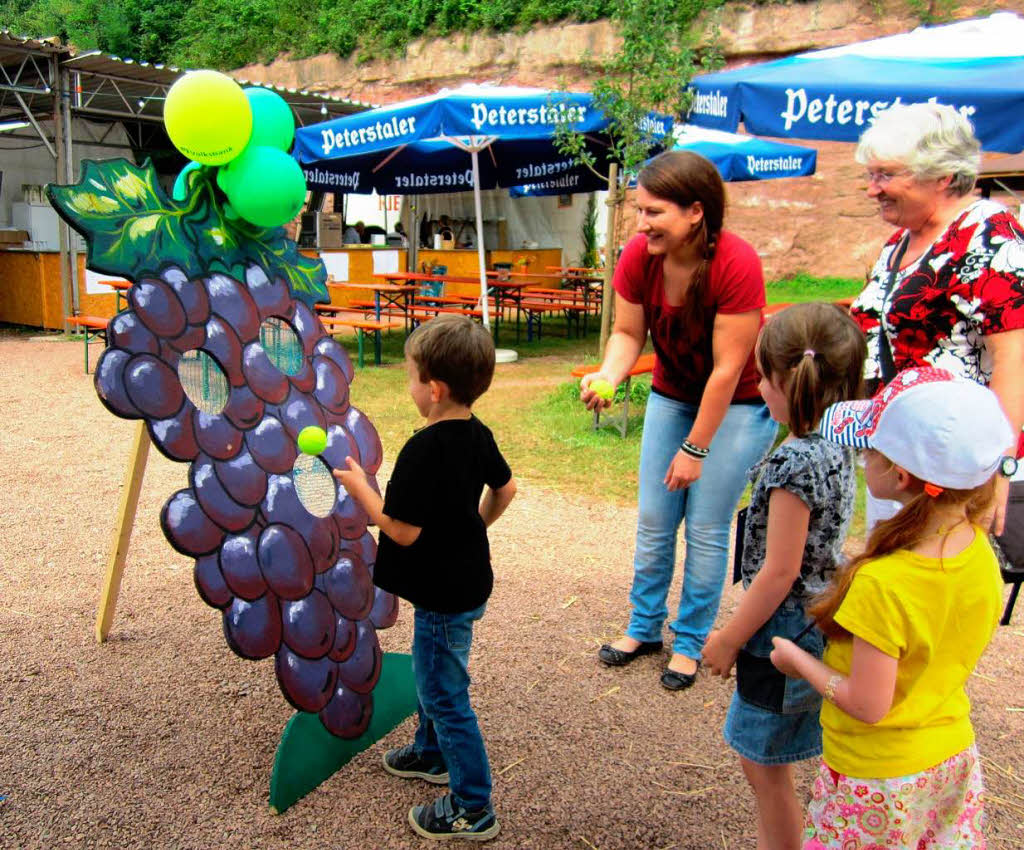 Kinderfest: Gar nicht so einfach, den kleinen Ball durch die Lcke in der Traube werfen.