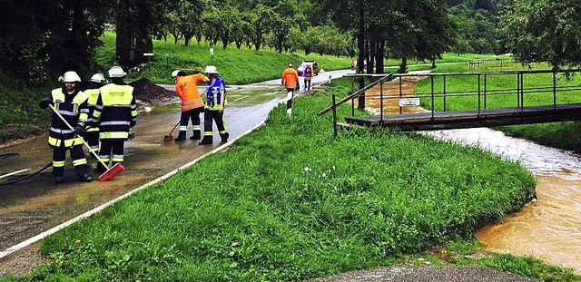 Wehrleute befreien die Strae von Schlamm und Gerll.  | Foto: Feuerwehr