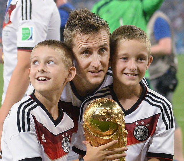 Augenblick des grten Erfolgs: Mirosl...it seinen beiden Shnen den WM-Pokal.   | Foto: DPA