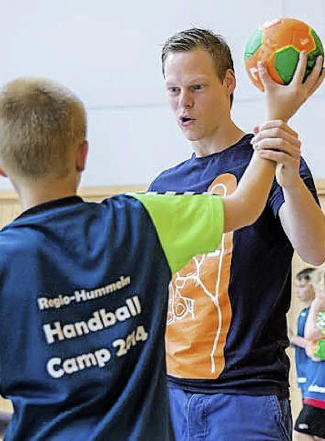So wird das gemacht: Der Handball-Nati...bt mit einem Jungen beim Hummel-Camp.   | Foto: Thomas Zeyner