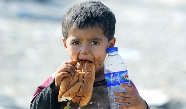 Endlich Wasser und Brot: ein irakisches Flchtlingskind im Norden des Landes   | Foto: AFP