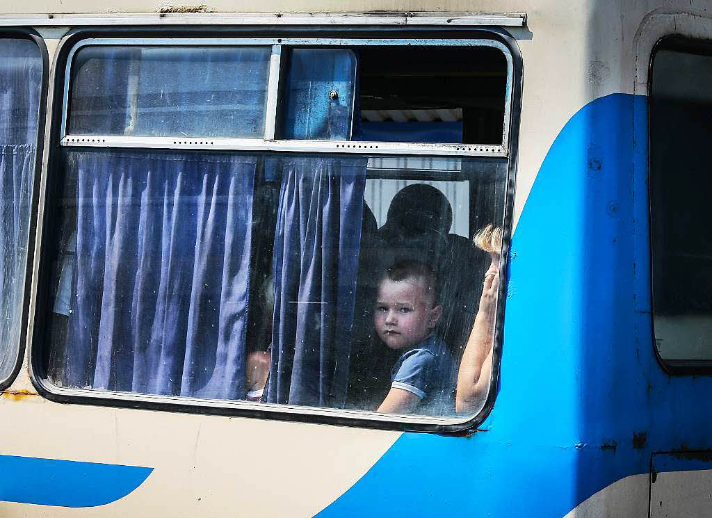 Ein Junge blickt aus dem Fenster eines der Busse die Donezk verlassen.