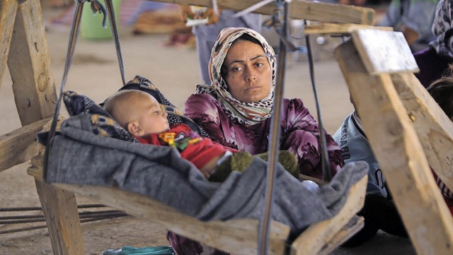 Diese jesidische Mutter und ihr  Kind ...or dem Terror der IS-Milizen fliehen.   | Foto: AFP