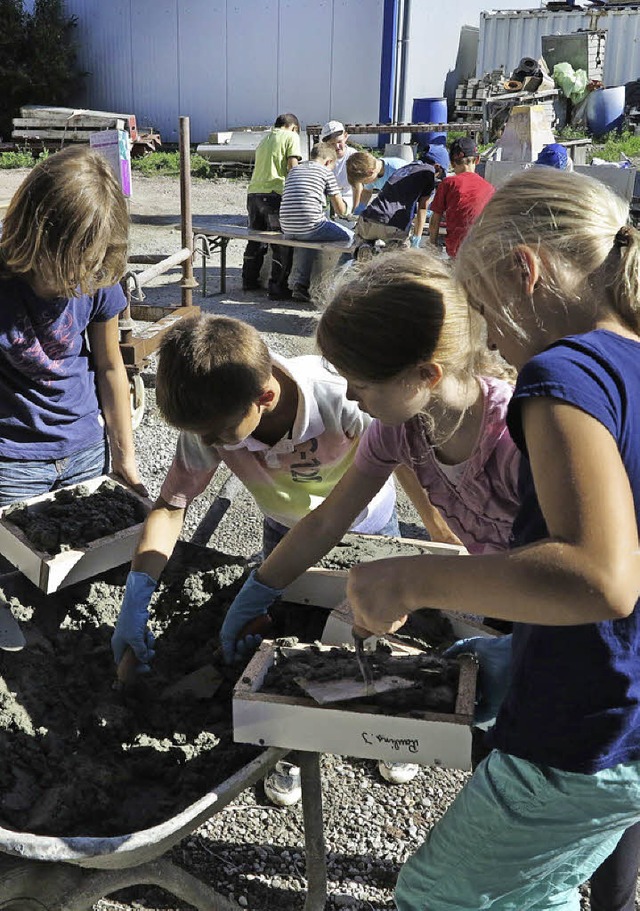 Eifrig fllen die Kinder ihre Formen mit dem grauen Brei.   | Foto: Philipp