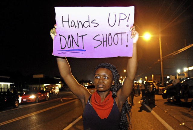 &#8222;Hnde hoch! Nicht schieen!&#82... diese Demonstrantin in die Hhe hlt.  | Foto: AFP