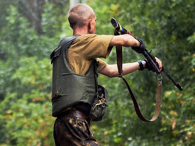 Ein ukrainischer Soldat durchkmmt ein...ischen Separatisten beschossen wurden.  | Foto: AFP
