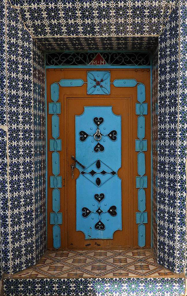 Ortrun Strzel: Fliesen und Metall in Blau.  Diese Tr habe ich auf meiner Fahrt durch Marokko fotografiert - anderes Land, andere Formen und Farben - und meist "Eigenbau" - und oft sehr schn!