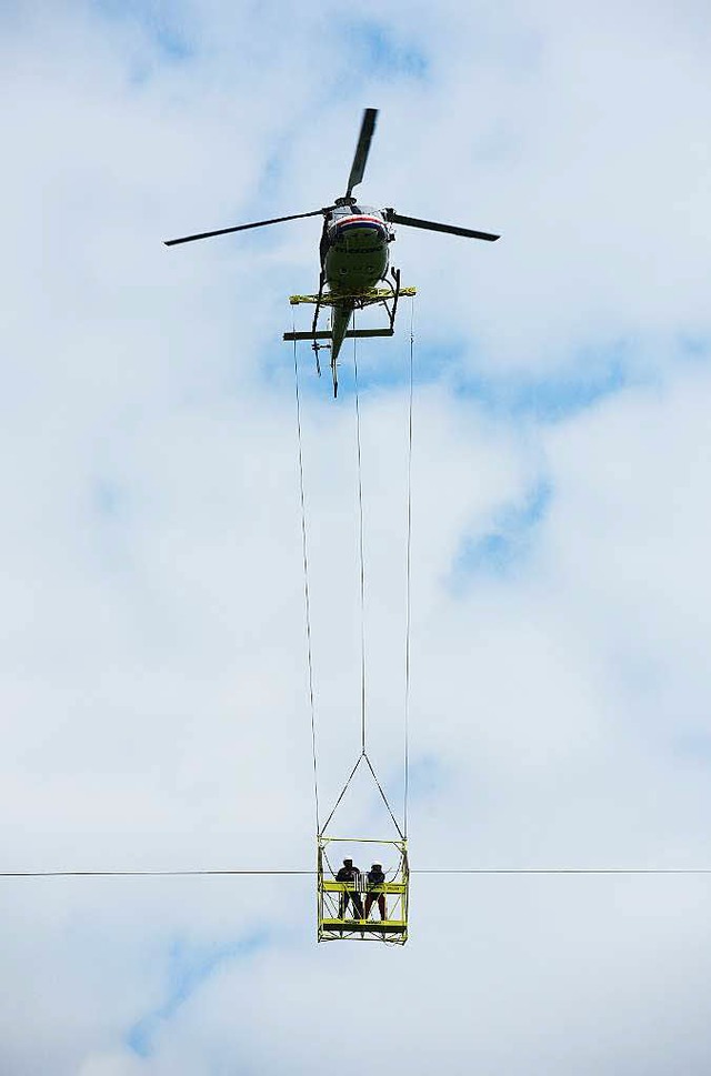 Mit dem Helikopter werden die Monteure an das Erdseil geflogen.  | Foto: Julius Steckmeister