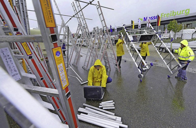 Im Nieselregen bauen Arbeiter die Badenmesse auf, die bis 21. September dauert.  | Foto: Ingo Schneider