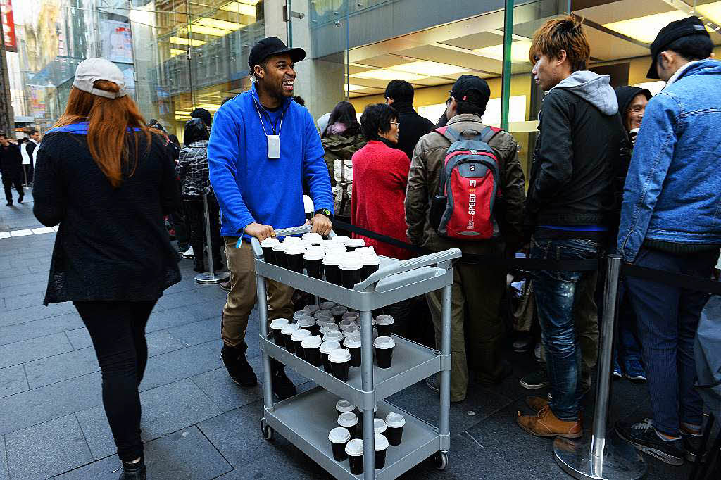 Apple Mitarbeiter in Sydney verteilten Kaffee an wartende Kunden.