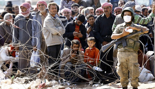 Stacheldraht und Erschpfung: Syrer, d...nd an der trkischen Grenze gelandet.   | Foto: dpa