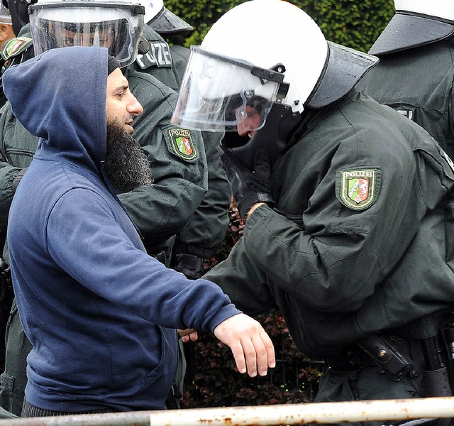 Gewaltbereites Milieu: Ein Polizist du... einer Demonstration einen Islamisten.  | Foto: dpa
