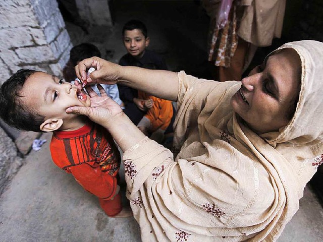 Eine Helferin verabreicht einem Kind eine Polio-Schluckimpfung.   | Foto: dpa