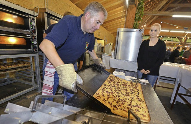 Michael Hannemann holt den Zwiebelkuchen aus dem Ofen.  | Foto: Rita Eggstein