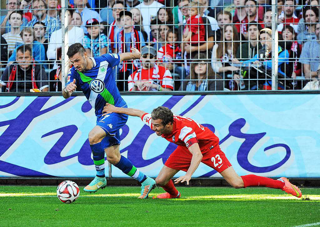 Nicht zu stoppen: Der Wolfsburger Matchwinner Daniel Caligiuri (blaues Trikot) enteilt hier dem Freiburger Kapitn Julian Schuster.