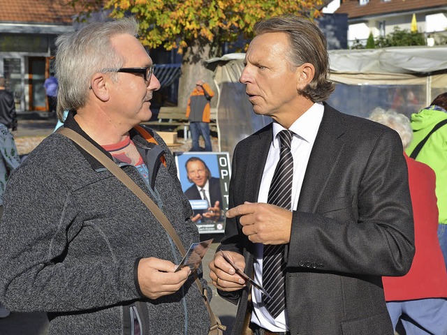 Michael Opitz (rechts) spricht Brger auf dem Markt an.  | Foto: Martin Eckert