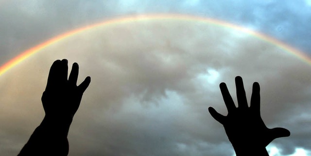 Wir fangen den Regenbogen: Zwei Kinderhnde greifen zum Himmel hinauf.   | Foto: dpa