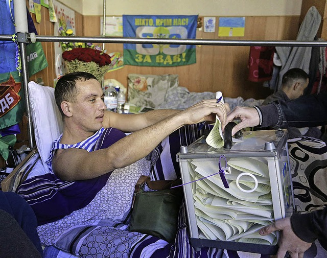 Ein verwundeter Soldat whlt in einem Militrhospital in Kiew.    | Foto: AFP