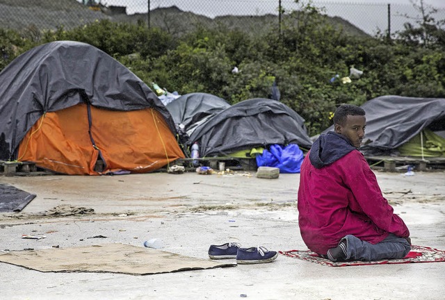 Ein Flchtling aus Eritrea betet am fr...Morgen auf einem Zeltplatz in Calais.   | Foto: dpa