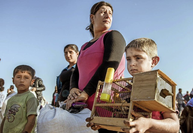 Mit Kind und Vogel: Syrische Flchtlinge auf dem Weg in die Trkei   | Foto: DPA