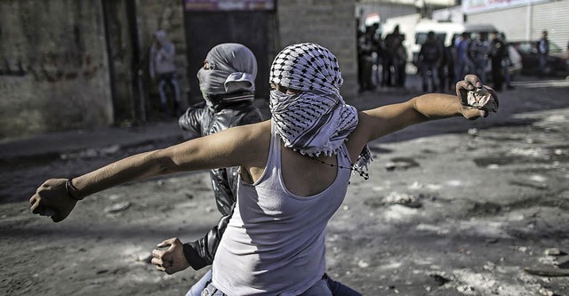 Junge Palstinenser bewerfen israelische Soldaten mit Steinen.   | Foto: DPA