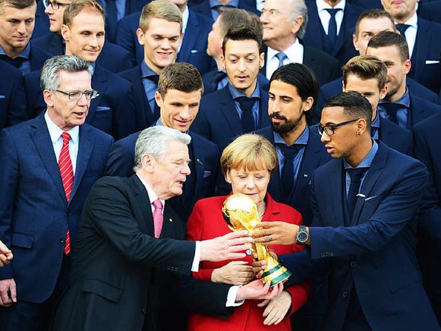 Darf ich auch mal halten? Bundeskanzle...nt Joachim Gauck und Jerome Boateng.    | Foto: AFP