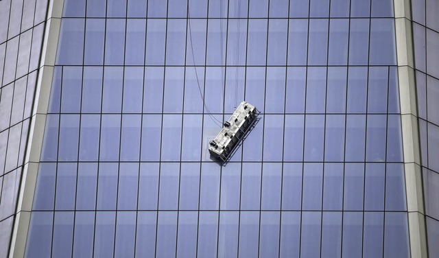 Arbeiter hngen am sthlernen Seil auf Hhe des 69. Stocks.  | Foto: dpa