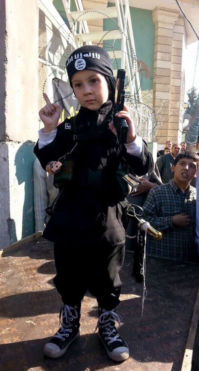 Ein Kind trgt die Kampfmontur des IS.   | Foto: DPA