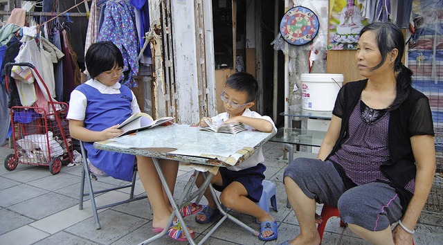 Law Lai-kuen mit ihren Enkeln vor ihrer Dach-Htte  | Foto: dpa/Hartwich (2)